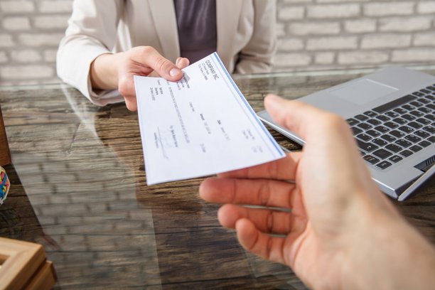 businesswoman-giving-cheque-to-her-employee